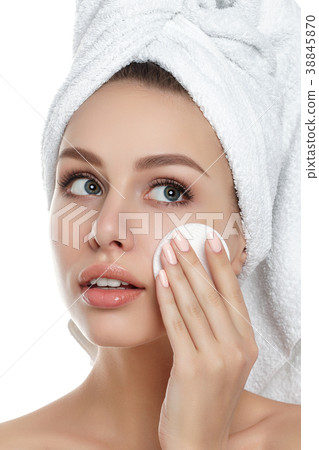 Young woman with towel on her hair cleaning makeup Young woman with towel on her hair cleaning makeup 38845870