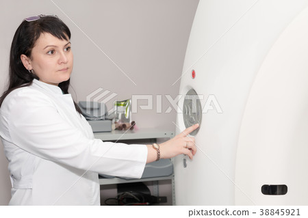 A female doctor pushing control button on CT A female doctor pushing control button on CT 38845921