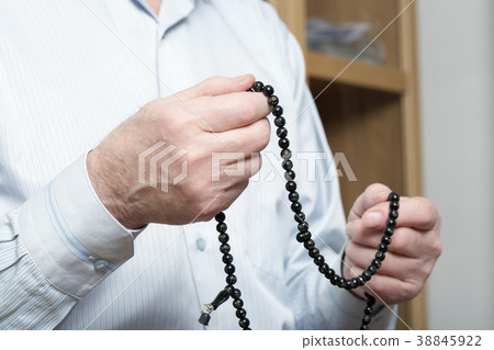 Praying hands of an old man with rosary beads Praying hands of an old man with rosary beads 38845922