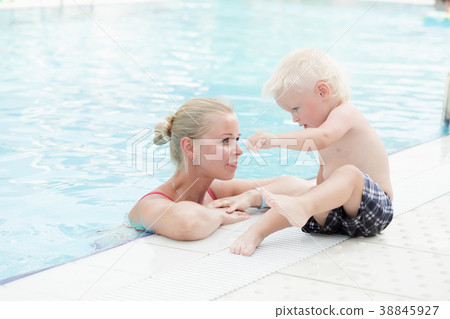 Mother and son have fun by a swimming pool 38845927