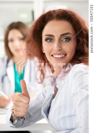 Smiling female patient showing thumb up 38847191