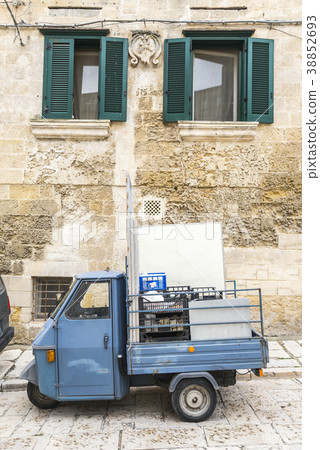 小型三輪卡車停在一扇帶百葉門的窗戶上 38852693