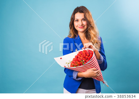 Bouquet of strawberries in the hands of a girl on 38853634