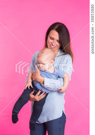 happy young mother with a baby child on pink happy young mother with a baby child on pink 38853880