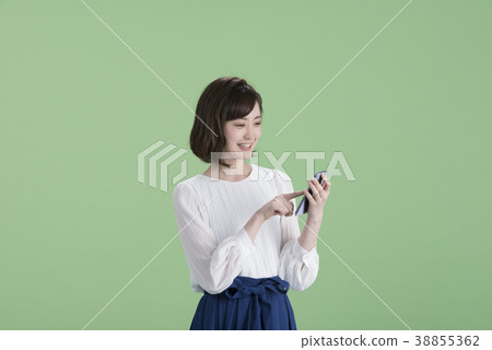 A young woman operating a smartphone 38855362