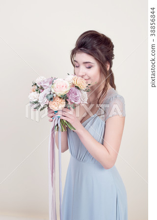 Half length beautiful female model holding a bouquet of flowers wearing in luxurious long lacy dress Half length beautiful female model holding a bouquet of flowers wearing in luxurious long lacy dress 38856844