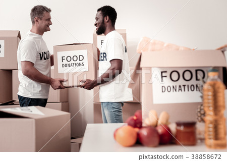 Delighted volunteers holding big parcel Delighted volunteers holding big parcel 38858672