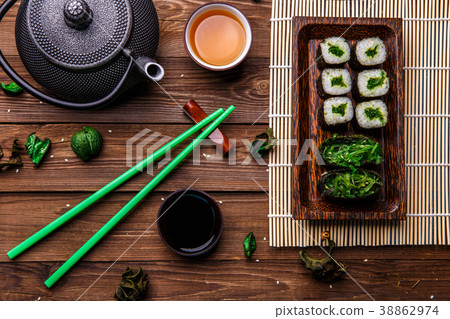 Wooden surface with rolls, teapot 38862974