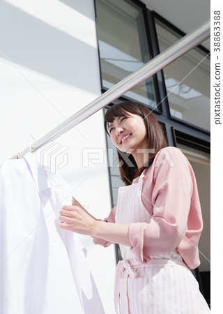 Housewife drying laundry 38863388