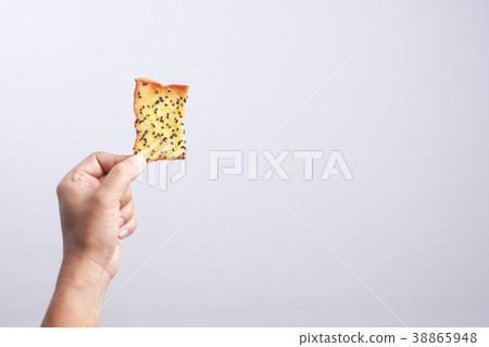 Hand holding butter rusk bread loaf with black sesame 38865948
