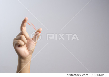 Hand holding elastic rubber band 38866040