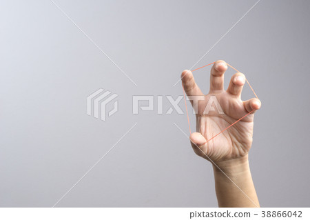 Hand holding elastic rubber band 38866042