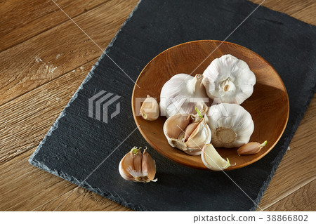 Garlic close up on wooden plate on rustic 38866802