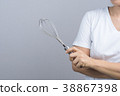Woman hand holding stainless balloon whisk 38867398