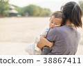 Sleeping Asian baby being held by his mother 38867411