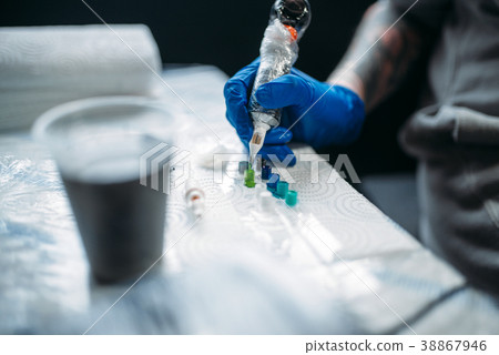 Female tattooer hands holds tattoo machine Female tattooer hands holds tattoo machine 38867946