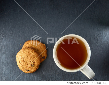 A glass cup of black tea with cookies on a dark A glass cup of black tea with cookies on a dark 38868162