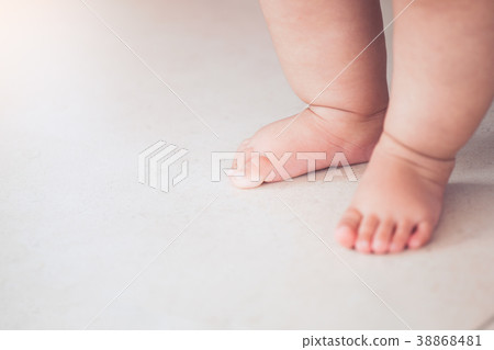 Small baby feet doing the first step on the floor 38868481