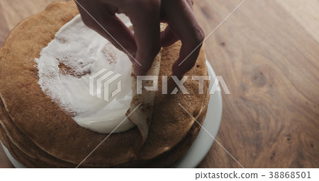 closeup of rolling pancake with sour cream closeup of rolling pancake with sour cream 38868501