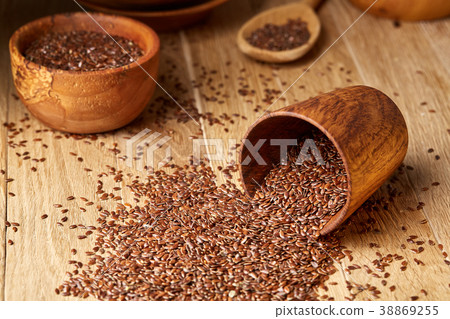 An overturned wooden bowl with linseeds on a 38869255