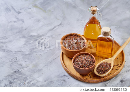 Flax seeds in bowl and flaxseed oil in glass 38869380