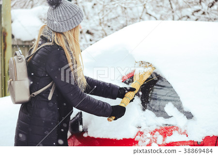 Winter portrait of a young woman cleaning snow Winter portrait of a young woman cleaning snow 38869484