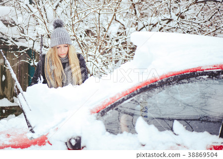 Winter portrait of a young woman cleaning snow Winter portrait of a young woman cleaning snow 38869504