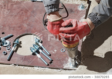 The builder rotates the nuts with an electric The builder rotates the nuts with an electric 38870265