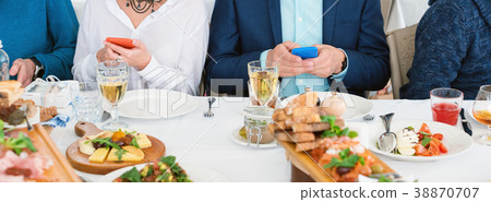 Friends sitting in cafe, eating and drinking Friends sitting in cafe, eating and drinking 38870707