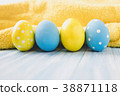 Blue and yellow Easter eggs on rustic background 38871118