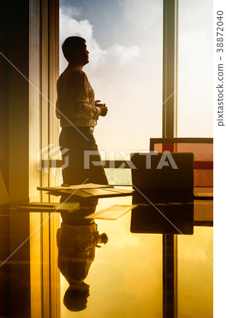 Business man standing on window looking at city 38872040