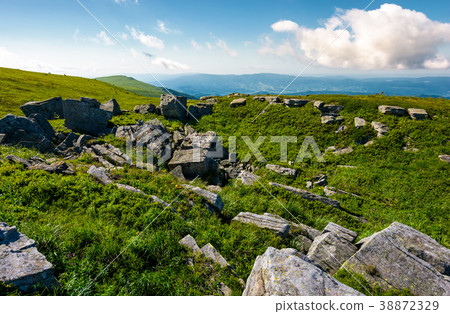 rocky formation on grassy hillside 38872329