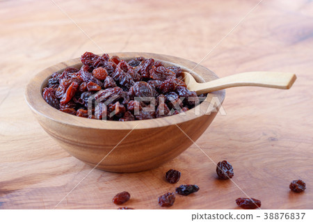 Raisin in bowl on wooden background. Raisin in bowl on wooden background. 38876837