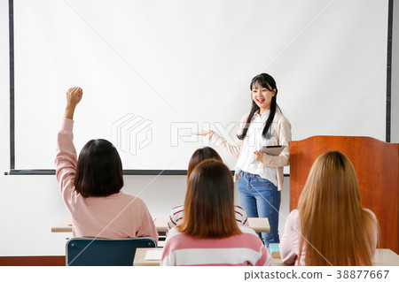 Campus life - female students in a classroom during class, studying together and taking selfie through mobile phone. 251 Campus life - female students in a classroom during class, studying together and taking selfie through mobile phone. 251 38877667