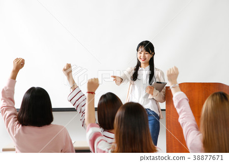 Campus life - female students in a classroom during class, studying together and taking selfie through mobile phone. 253 Campus life - female students in a classroom during class, studying together and taking selfie through mobile phone. 253 38877671