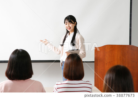 Campus life - female students in a classroom during class, studying together and taking selfie through mobile phone. 255 Campus life - female students in a classroom during class, studying together and taking selfie through mobile phone. 255 38877673