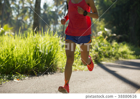 woman running on morning tropical forest trail 38880616