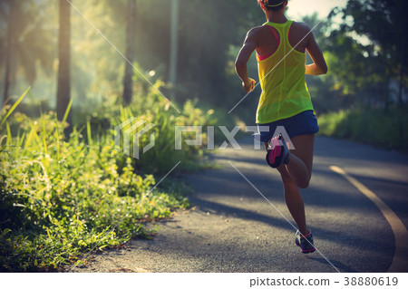 woman running on morning tropical forest trail 38880619