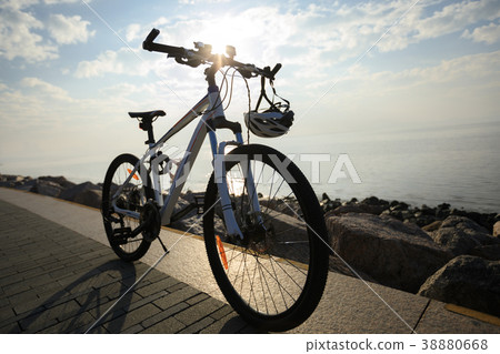 mountain bike with helmet on sunrise seaside 38880668