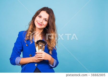 Young make-up artist with brushes on blue 38882805