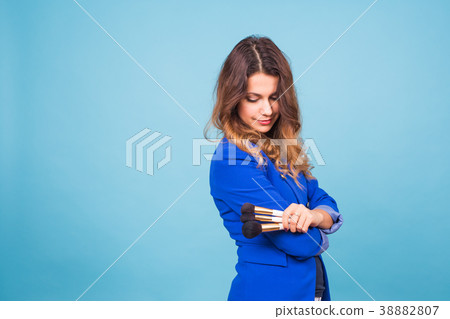 Beautiful make-up artist with brushes on blue 38882807