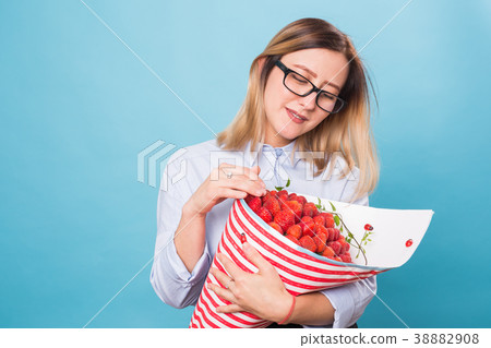 Beautiful woman holding bouquet made of strawberry Beautiful woman holding bouquet made of strawberry 38882908