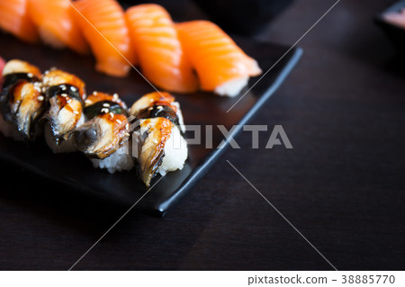 Salmon and eel sushi on black plate in restaurant 38885770