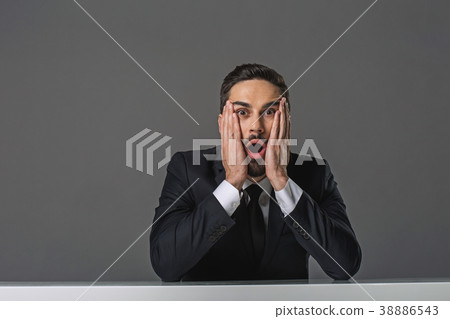 Shocked man sitting at the table Shocked man sitting at the table 38886543