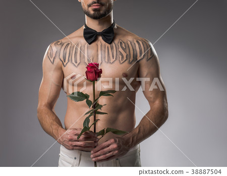 Shirtless man standing with flower Shirtless man standing with flower 38887504