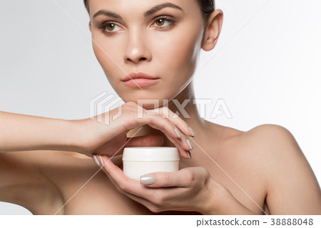 Calm girl holding cosmetic product 38888048