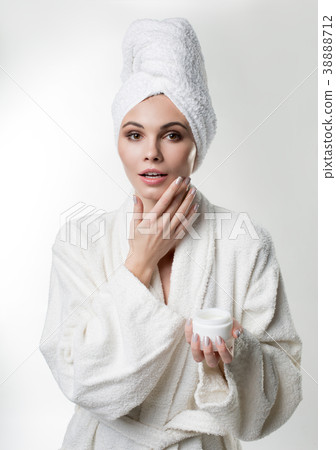 Calm girl putting on cream after spa procedure Calm girl putting on cream after spa procedure 38888712