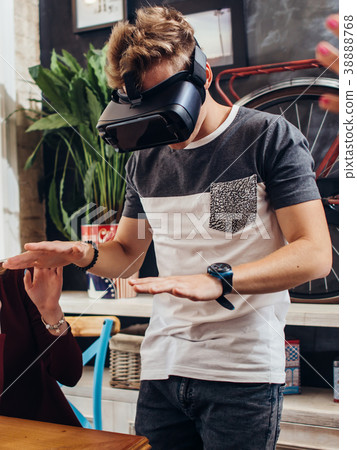 Amazed young man wearing virtual reality goggles 38888768