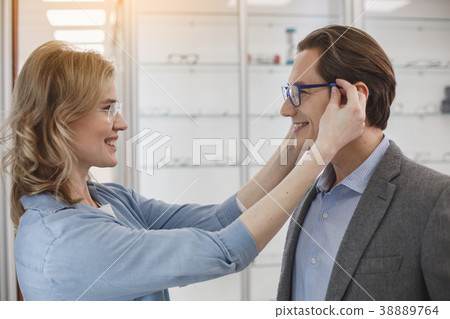 Cheerful husband and wife in optician shop Cheerful husband and wife in optician shop 38889764