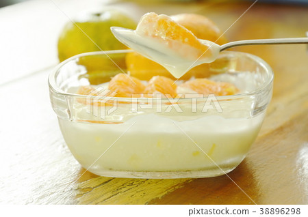 yogurt topping orange scooping on spoon yogurt topping orange scooping on spoon 38896298